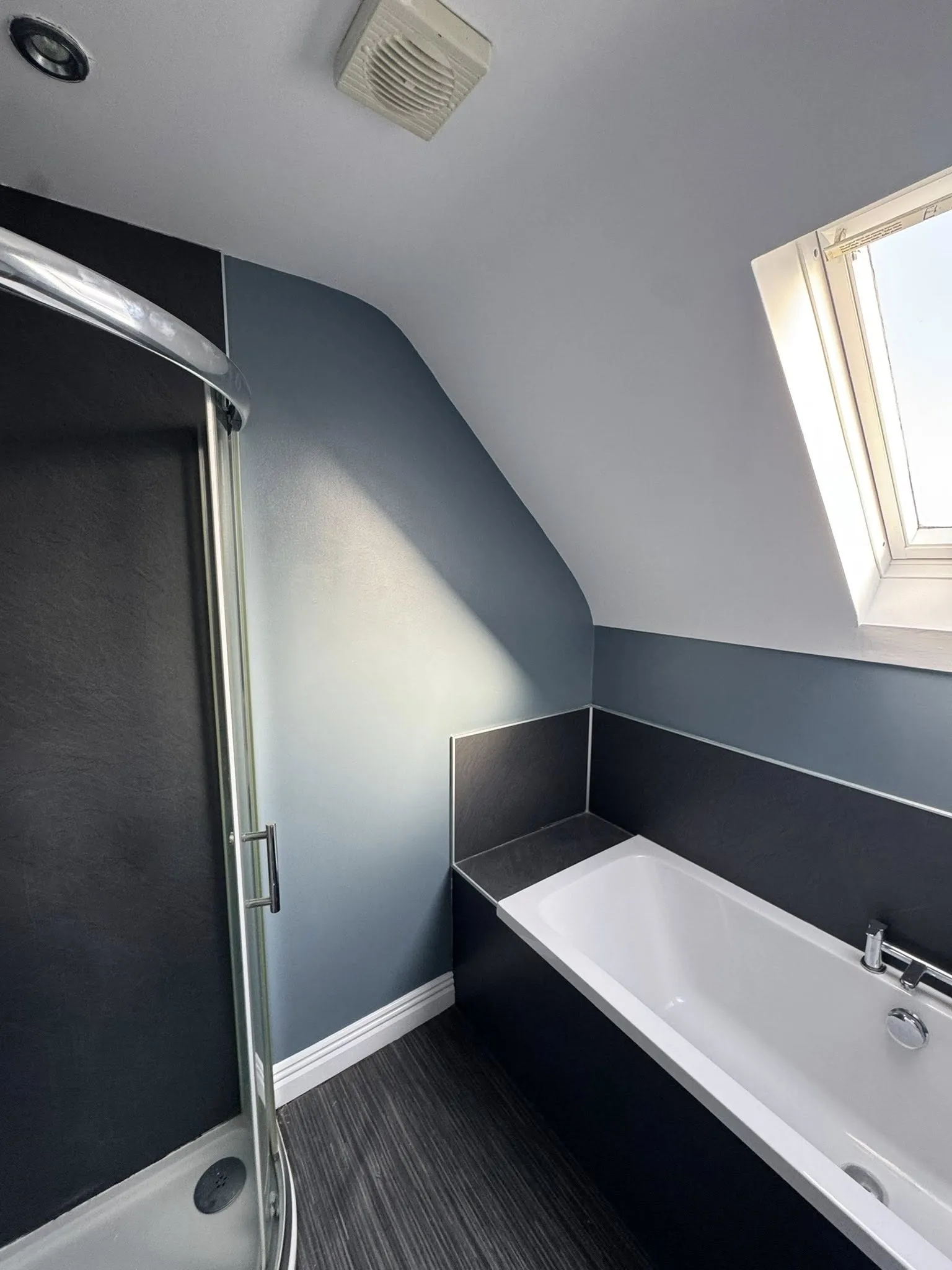 grey painted small bathroom with black tiles