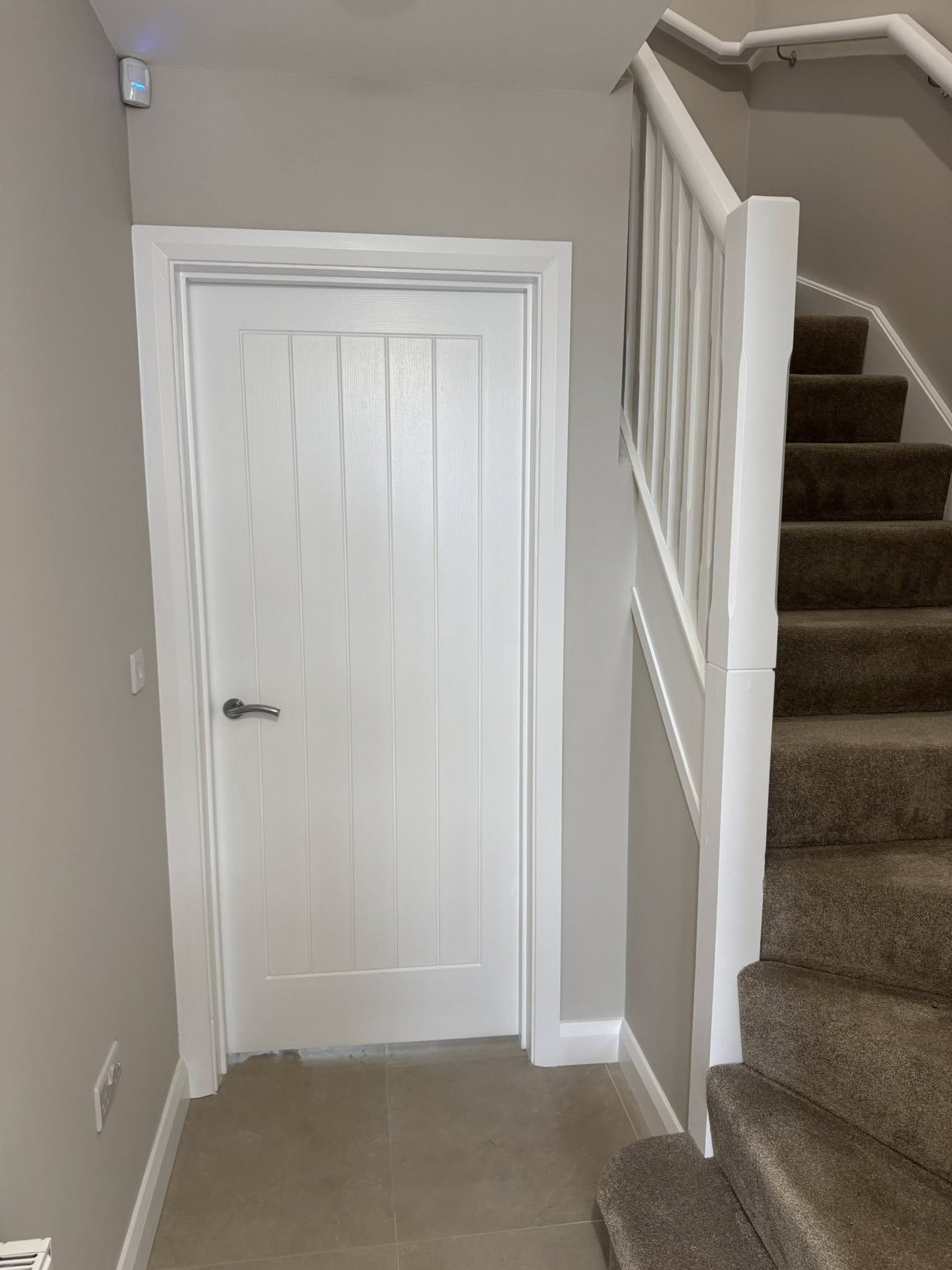Fresh white painted door with light grey walls
